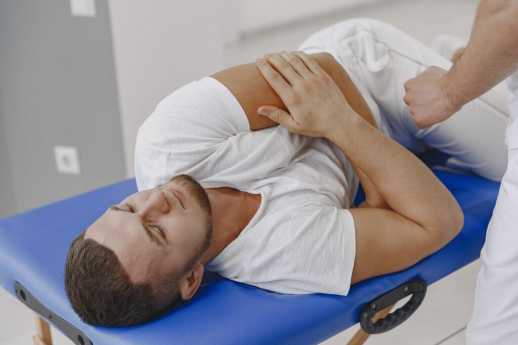 Hombre recibiendo tratamiento de fisioterapia en la camilla